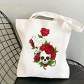 Vintage canvas tote bag with skull and rose print displayed on a black metal chair - 2-Double Skulls Red Rose