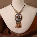 Sautoir bohème vintage avec perles colorées, pendentif en pierre et pompons sur un mannequin - X445-2 Style 3