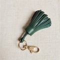Détail d'un porte-clés à franges en cuir vert foncé avec anneau et fermoir dorés polis - Vert Foncé