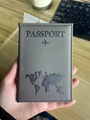 Dark gray faux leather passport holder featuring an embossed world map and airplane icon - Dark Gray