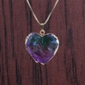 Macro shot of a heart-shaped purple and green stone pendant with a gold metal chain - Purple and Green Texture - Copper