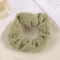 Chic green knitted oversized scrunchie placed on a minimalist beige ceramic plate - Grass Green