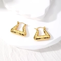 Macro detail of gold geometric triangle hoop earrings with vintage engraved textures - Retro Triangle