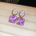 Detail of geometric wave earrings with white oval and purple square in gold frame - Purple
