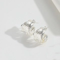 Macro shot of silver-toned multilayered geometric hoop earrings with a metallic finish - Multi-layer Spiral Studs / Silver