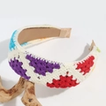 Close-up of handmade crochet headband featuring colorful geometric knit patterns - Flat Rainbow Triangle