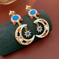 Nahaufnahme der Vintage Mond-Ohrringe mit blauen Kristallen und weißen Perlen - Silber-Ohrstecker-Stil / Gold-Mehrfarbig