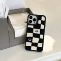 Detalle de funda de felpa a cuadros blancos y negros con suave textura bordada - Bordado de Felpa con Cara Sonriente de Tablero / iPhone 13 Pro Max