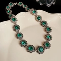 Macro shot of vintage silver floral link necklace with emerald green crystals on ceramic - 63# Green Vintage Flower Necklace