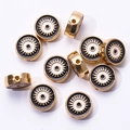 Détail macro de perles œil de turc dorées en alliage pour la création de bijoux DIY - Noir