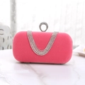 Close-up of pink velvet evening bag with sparkling diamond-encrusted ring and tiered fringe - Pink