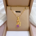 Close-up of golden swan necklace with pink crystal and pavé diamonds in a jewelry box - Purple Diamond Swan Necklace (E416) / Gold/Purple