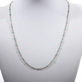 Detail view of a gold-plated beaded chain necklace with turquoise enamel beads on a bust - Gold + Pine Green
