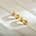 Dettaglio macro degli orecchini a U placcati oro con finitura in smalto bianco sporco - Bianco