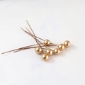 Detailed close-up of matte gold berry picks on a light marble texture background - 8mm / Gold