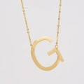 Détail macro d'un collier en acier inoxydable doré 18K avec pendentif lettre G - Lettre G / Or
