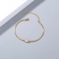 Detail view of gold metal bangle featuring an oval zircon center and adjustable clasp - Oval Zirconia