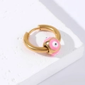Golden titanium steel hoop earring with pink enamel evil eye bead on white texture - Gold-Pink