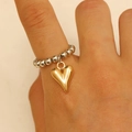 Bague élastique en perles argentées avec un pendentif en forme de cœur doré poli - Bague Cœur Or 12081