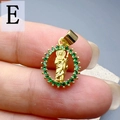 Close-up of a gold oval Jesus pendant with green zircons held by hand for scale - Style E-Green Zirconia