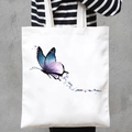 White canvas tote bag featuring watercolor butterfly print carried by a model - Watercolor Butterfly (STD707-A)