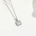 Detailopname van een zilveren vierkante hanger met punttextuur op een fijne metalen ketting - Zilveren Vierkant