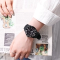 Gros plan d'une montre à quartz noire avec bracelet en résine portée au poignet - Noir