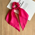 Detailopname van rozerode satijnen scrunchie met lange linten op een bureau-achtergrond - Rozerood Satijnen Lint