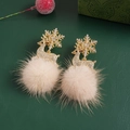 Close-up of golden reindeer and snowflake earrings with beige plush balls on green background - #17 Gold Snowflake Reindeer Pom Pom