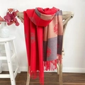 Detailed shot of camellia jacquard scarf with tassels draped on a wooden chair - Dandelion Red