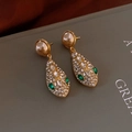 Detail of snake head earrings with gold pearls, green stone eyes, and sparkling rhinestones - Pearl Snake Head Rhinestone Emerald Drop Earrings (50#)