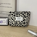 Detalle del neceser de pana con estampado de leopardo y cremallera de metal sobre madera - Leopardo Beige