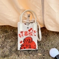 Close-up of knit cream shoulder bag featuring cartoon tigers and festive Chinese characters - Good Fortune Tiger Beige