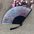 Traditional folding fan featuring pink peach blossoms and black bamboo ribs with tassel - No.41 Peach Blossom Landscape