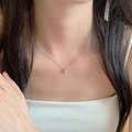 Close-up of S925 sterling silver four-leaf clover pendant with sparkling zircon on a model - White Gold