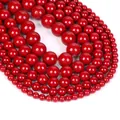 Macro shot of assorted red natural stone beads in circular arrangement with waxy luster - Cinnabar Style Jade