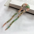 Detail of pink and green marbled acetate U-shaped hair pin on white fabric - Fresh Green