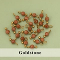 Flat lay of goldstone pendant beads with stainless steel pins for DIY jewelry making - Goldstone Style (13S) / 50 Pieces / Golden Brown