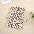Close-up of leopard print cotton drawstring storage bag with natural muslin texture - Yellow Leopard