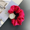 Detail view of red silk scrunchie watch band with gold case on a stylish dark surface - Rose Red