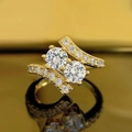 Vista macro de anillo dorado con dos diamantes redondos y banda cruzada de pavé - US 7 / Dorado