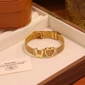 Détail d'un bracelet en maille dorée avec breloque cœur et lettre W en coffret cadeau luxe - Lettre W
