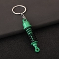 Dettaglio del portachiavi ammortizzatore auto verde e nero con design a molla realistico - Verde