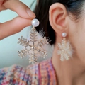 Detail of Christmas snowflake earrings with white pearl and plush pom-poms worn by a model - Gold Snowflake Pom-pom