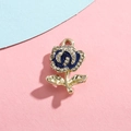 Macro detail of rose pendant charm with blue enamel petals and sparkling rhinestones - Royal Blue Rose Gold