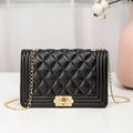 Quilted black chain bag with gold hardware and turn-lock on a clean white countertop - Black Diamond Pattern