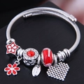 Silver woven bracelet with red enamel flowers, colorful beads and a sparkling heart pendant - Red