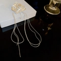 Macro detail of silver orchid earring with pleated texture and long metal tassels - Silver (Silver Pin)