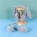 Cute grey plush earmuffs with moving ears and long straps on a wooden hat stand - One Size / Carrot-Grey