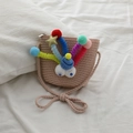 Beige woven straw crossbody bag for kids featuring colorful pom-poms and cute eyes - Pink